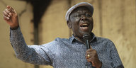 Porträt Morgan Tsvangirai - ers spricht mit erhobenem Arm in ein Mikrofon
