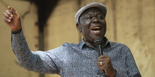 Porträt Morgan Tsvangirai - ers spricht mit erhobenem Arm in ein Mikrofon