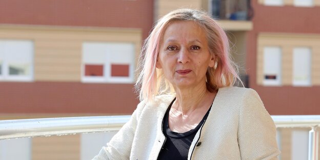 Eine Frau steht auf einem Balkon Eine Frau steht auf einem Balkon