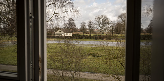 Blick aus dem Fenster auf ein fernes weißes Häuschen