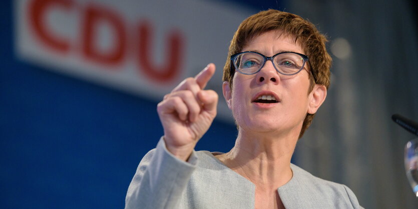 eine Frau zeigt mit dem rechten Zeigefinger nach vorne, im Hintergrund ein CDU-Logo