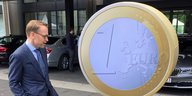 Bundesbankpräsident Jens Weidmann vor einer riesigen Euromünze