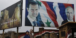 Ein Plakat mit den Fotos von Syriens Präsident Assad und Russlands Präsident Putin
