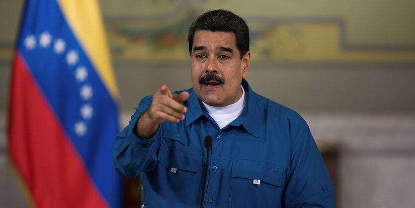 Präsident Nicolás Maduro neben der venezolanischen Flagge