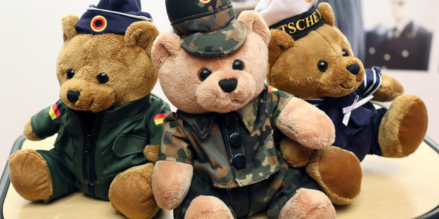 Drei Plüschbären in Bundeswehruniform sitzen nebeneinander