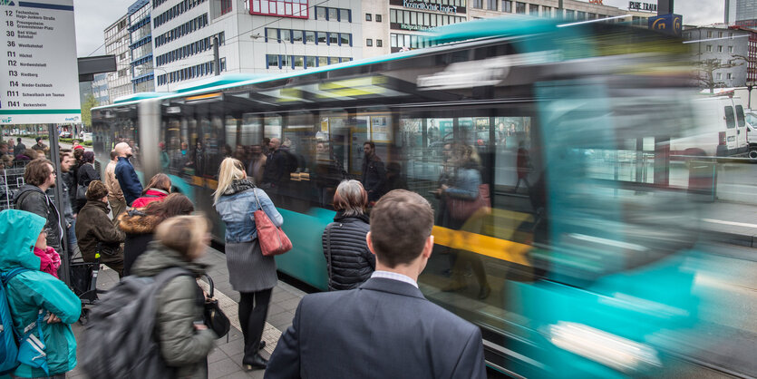 Menschen in Frankfurt an Bushaltestelle