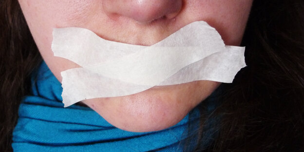 Der Mund einer Frau ist mit weißem Tape zugeklebt