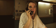 Eine Frau spricht in einen Telefonhörer