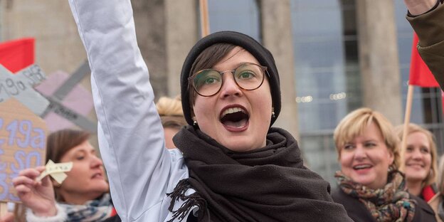 Menschen vor dem Bundestagsgebäude strecken ihre Fäuste nach oben und rufen laut