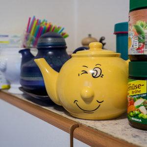 Gelbe Teekann mit Smiley-Gesicht