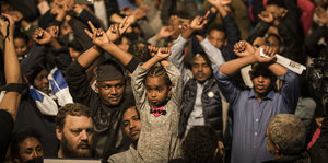 Flüchtlinge heben die Hände wie mit Handschellen gefesselt