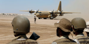Soldaten und ein Militärflugzeug auf einem Flughafen