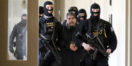 Polizisten eskortieren den syrisch-kurdischen Politiker Salih Muslim (M) in ein Gericht.