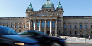 zwei Autos rasen am Bundesverwaltungsgericht in Leipzig vorbei