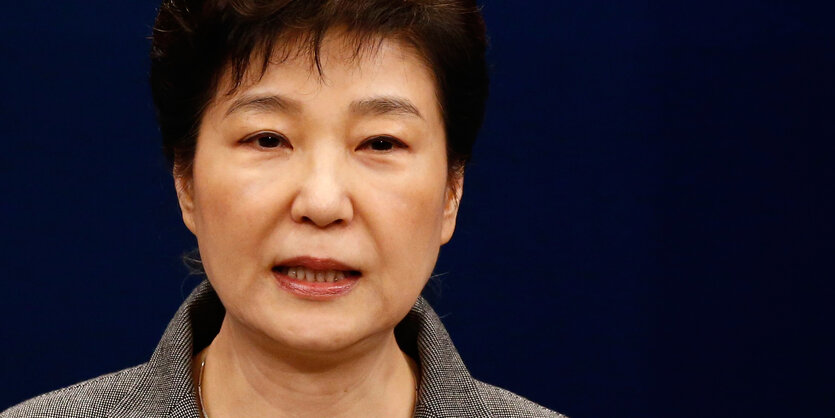 Park Geun-hye steht vor einer dunklen Wand