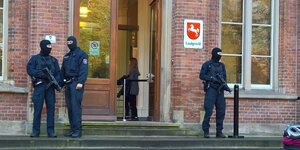 Drei Polizisten mit Sturmhauben und Maschinengewehren stehen vor dem Eingang des Oldenburger Landgerichts.