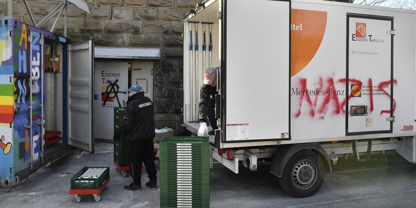 Helfer entladen einen Lkw, auf dem "Nazis" steht