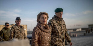 Von der Leyen geht mit Soldaten durch ein Feldlager