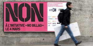 ein Mann läuft an einem Plakat vorbei, auf dem „NON“ steht