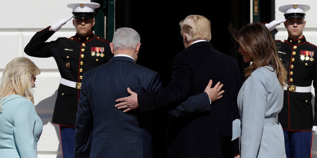 Trump und Netanjahu gehen gemeinsam ins Weiße Haus, sie sind von hinten zu sehen und haben den Arm um den jeweils anderen gelegt