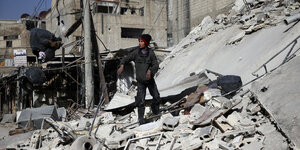 Ein Junge steht in der belagerten Stadt Duma auf Trümmern