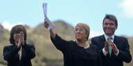 die chilenische Präsidentin in einem weißen Sakko inmitten von Kindern