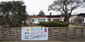 Protestplakat am gartenzaun: "Natur gegen Betonwüste"