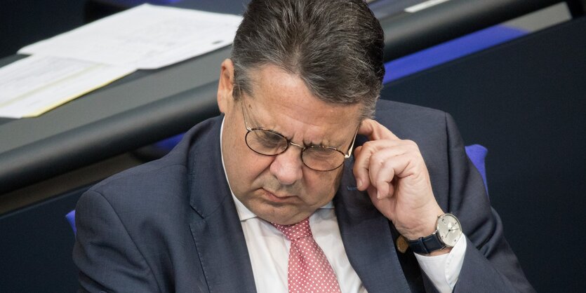 Sigmar Gabriel fasst sich ans Ohr und guckt dabei missmutig nach unten