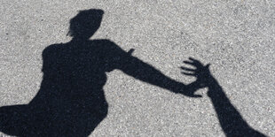 der Schatten einer Person, die eine Hand abwehrt