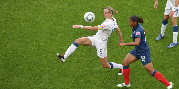 Die englische Fußballerin Faye White setzt sich gegen ihre Gegenspielerin durcg
