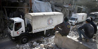 Mitglieder des Zivilschutzes sehen Hilfskonvois in der Ost-Ghouta zu