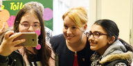 Franziska Giffey in der Mitte zwischen zwei Mädchen, die ein Selfie mit ihr machen