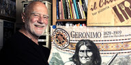 Achim Bergmann vor Bücherregal und Geronimo-Fahne