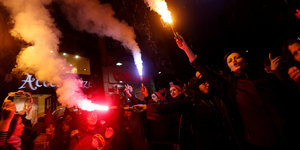 Demonstrantinnen rufen und halten Leuchtfeuerwerk in den Händen