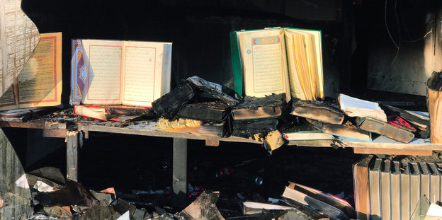 Aufgeschlagene Gebetsbücher stehen in einem von einem Feuer zerstörten Gebäude an der Berliner Kühleweinstraße, in der ein Moscheeverein untergebracht ist