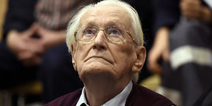 Ein alter Mann mit weißem Haar und Brille schaut nach oben