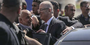der palästinensische Premier Rami Hamdallah steigt aus einem Auto. Er ist umringt von anderen Personen