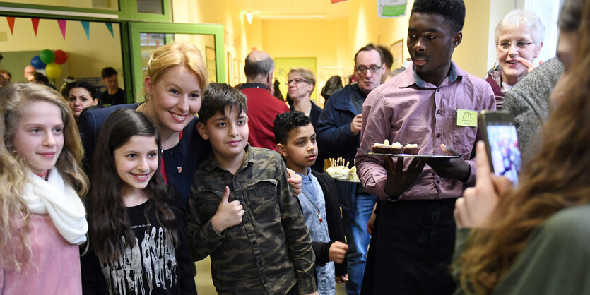 Neuköllns Bezirksbürgermeisterin Franziska Giffey (SPD) macht bei der Eröffnung einer sanierten Schultoilettenanlage in der Hans-Fallada-Schule Fotos mit den Schülerinnen und Schülern