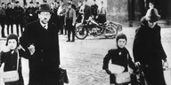 Eine jüdische Familie flüchtet unter den höhnischen Blicken von Nazis im Juni 1939 aus dem Memelland mit Ziel Litauen.