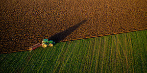 Ein Traktor pflügt ein großes Feld
