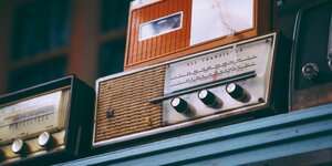 alte Radios auf einem blauen Regalbrett