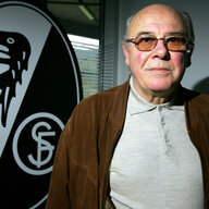 Der ehemalige Präsident des FC Freiburg, Achim Stocker, vor einem Vereinslogo