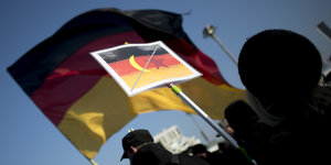 Schild mit Deutschlandfahne und durchgestrichenem Halbmond