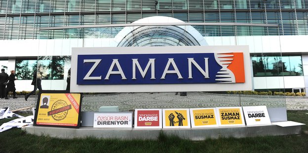 Plakate mit Aufschrift unter dem Schild mit dem Zeitungslogo vor dem „Zaman“-Redaktionsgebäude