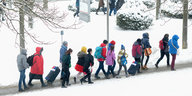 Menschen laufen auf einem Weg durch den Schnee