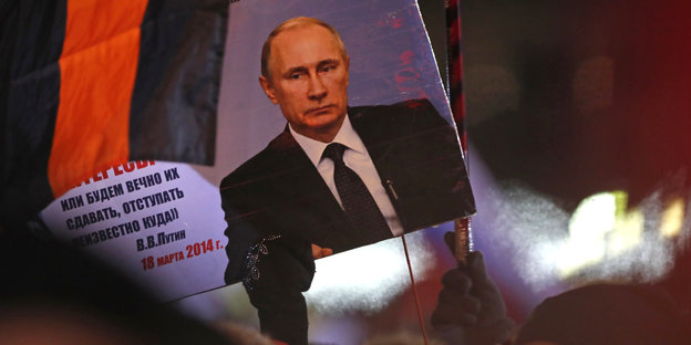 Putins Gesicht auf einem Plakat