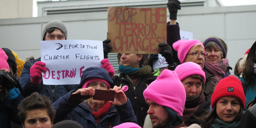 Männer und Frauen mit rosa Mützen und Proteschildern