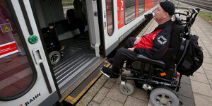 Ein Rollstuhlfahrer rollt in einen Zug