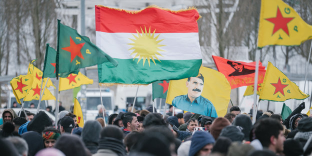 Bei einer Demo gegen die türkische Militäoffensive in Nordsyrien schwenken Menschen die kurdische Flagge und auch die verbotene Fahne des PKK-Führers Öcalan