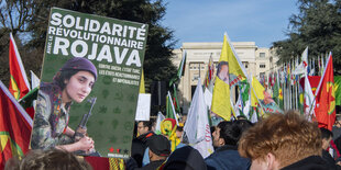 Demonstranten mit der Flagge der kurdischen Region Rojava